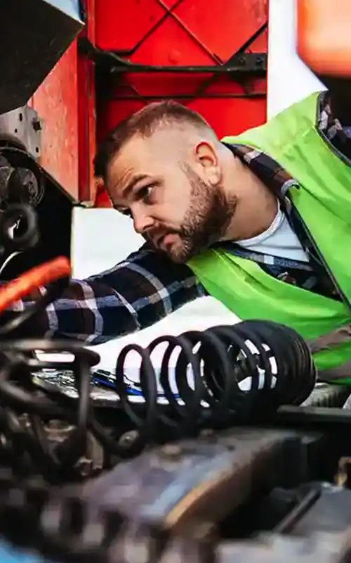 A man works on a truck engine 