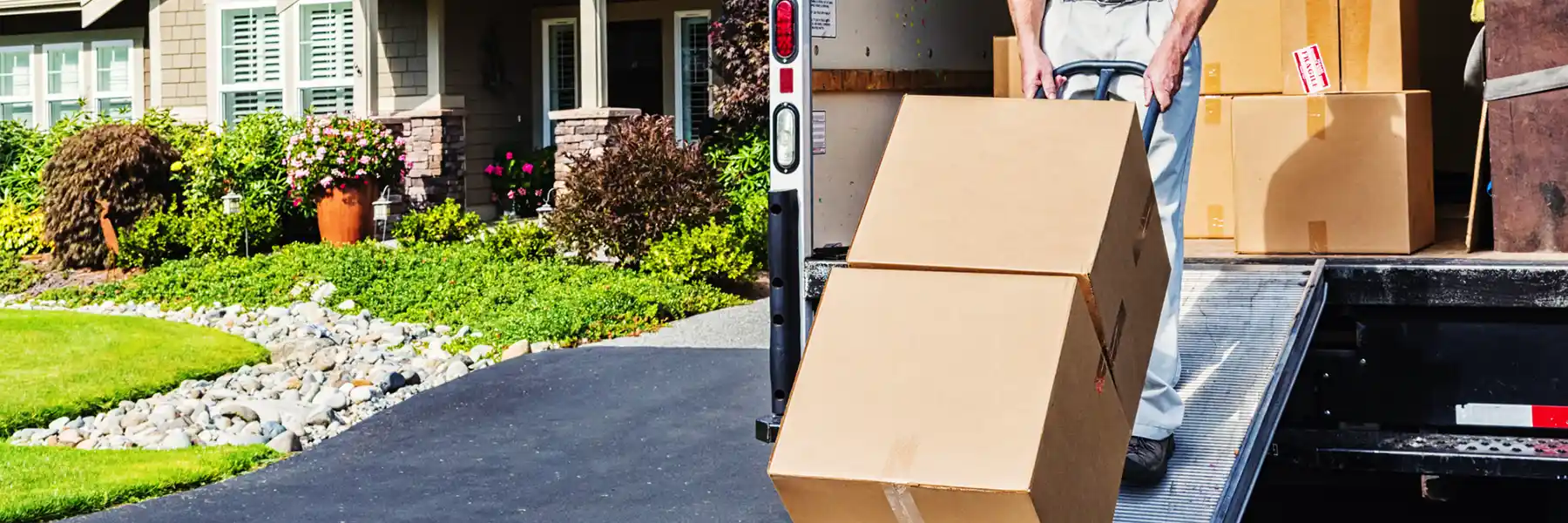 A moving truck and worker unload boxes