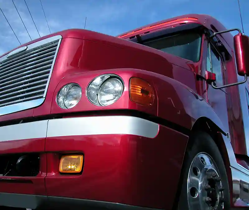 Close up of the front of a bright red hauler truck cab